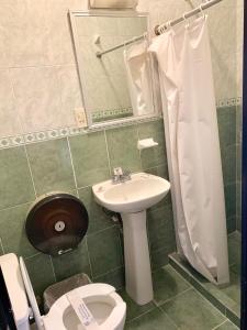 y baño con lavabo, aseo y ducha. en Hotel Guadalajara, en San Luis Potosí