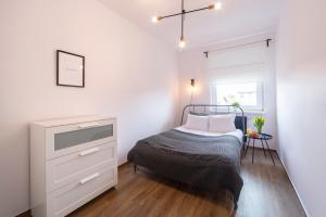 a bedroom with a bed and a dresser and a window at Apartament Alicante Górny Sopot by Renters in Sopot