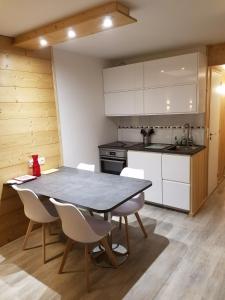 een keuken met een tafel en stoelen in een kamer bij ARC 1800, Residence Pierra Menta in Arc 1800