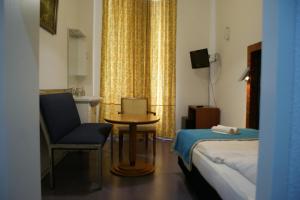 een hotelkamer met een bed, een tafel en een stoel bij Hotel Garni Aaberna in Berlijn