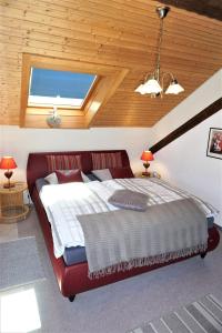 un letto rosso in una camera con soffitto in legno di Haus Schluchseeblick a Schluchsee