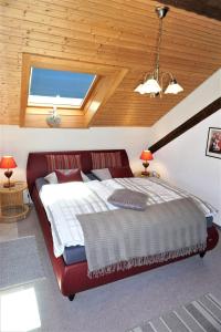 a red bed in a room with a wooden ceiling at Haus Schluchseeblick in Schluchsee