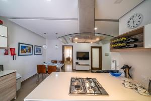 a kitchen and living room with a stove top oven at Pebbles, apartment 1 in Marsalforn