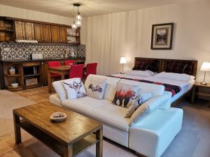 a living room with a couch and a bed at Family apartment in Tatranska Lomnica in Vysoke Tatry - Tatranska Lomnica.