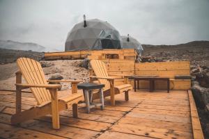 a group of wooden benches sitting on a wooden deck at Odom Retreat in Kfardebian