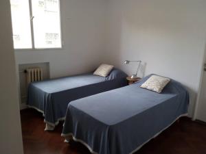 two beds in a room with blue sheets and a window at Depto centrico, 90 m2, 2 habitaciones in Rosario