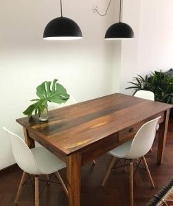 una mesa de madera con sillas blancas y una maceta en Depto centrico, 90 m2, 2 habitaciones en Rosario