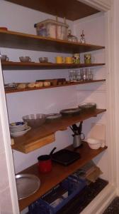 una cocina con estanterías de madera con tazones y platos en Depto centrico, 90 m2, 2 habitaciones en Rosario