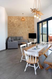 Aelia Luxury Villa في أموبي: غرفة معيشة مع طاولة وكراسي وأريكة
