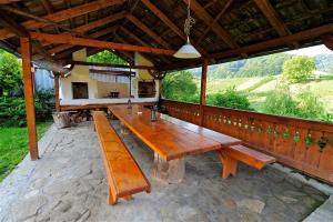 a group of wooden benches sitting on a patio at Transylvanian country house in Veţca