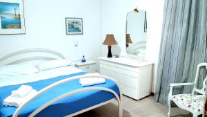 een slaapkamer met een bed met een spiegel en een stoel bij Seaside village Catania in Catania