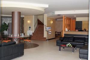 a living room with couches and a table and a staircase at Europalace Hotel Todi in Todi