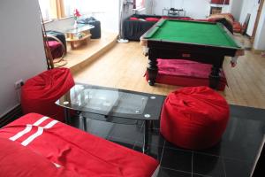 a living room with a pool table and red chairs at Privatzimmer Hagen in Hagen