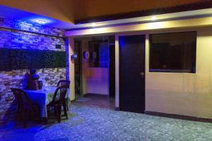 a room with a table and chairs and a blue light at Hospedaje el viajero-Aeropuerto in Lima