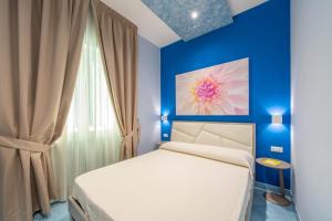 a bedroom with a white bed and a blue wall at La Casa del Poeta - Appartamento Ravello in Maiori