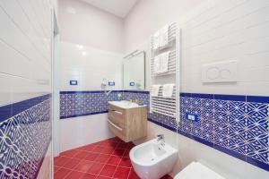 a blue and white bathroom with a sink and a toilet at La Casa del Poeta - Appartamento Ravello in Maiori