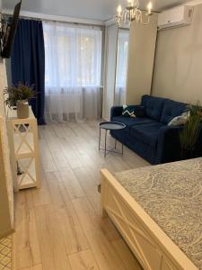 sala de estar con sofá azul y mesa en Sisters apartment en Chernihiv