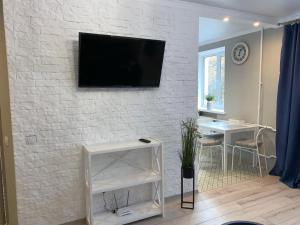 a living room with a tv on a white brick wall at Sisters apartment UKR in Chernihiv