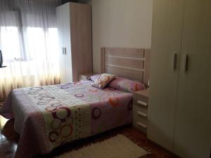 een kleine slaapkamer met een bed en een dressoir bij PISO CERCA DEL SARDINERO in Santander