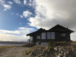 una casa en la cima de una colina junto a un cuerpo de agua en Veslehytta - 5 person cabin en Ål