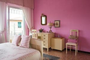 a bedroom with purple walls and a bed and a dresser at B&b Golfo dei Poeti in Lerici