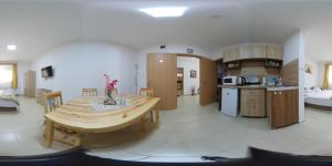 cocina con mesa de madera en una habitación en Juniperus Apartman, en Tiszaújváros
