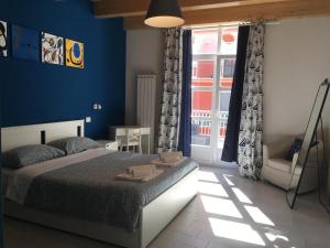 1 dormitorio con paredes azules, 1 cama y ventana en Sagittabondo, en Campobasso