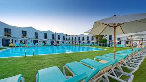 a pool with lounge chairs and an umbrella at FBC Fortuny Resort - Adults Only in Maspalomas
