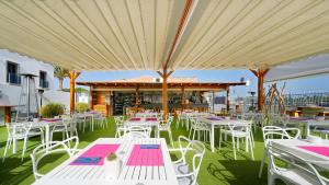 a group of tables and chairs under a large umbrella at FBC Fortuny Resort - Adults Only in Maspalomas