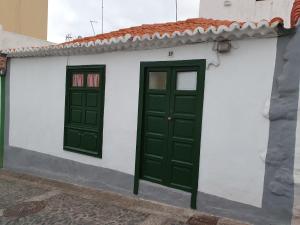 ein weißes und grünes Gebäude mit zwei grünen Türen in der Unterkunft LA CASITA CALLE EL TANQUE in Santa Cruz de la Palma