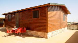 Cabaña de madera pequeña con mesa y sillas en El Mirador De La Moraña, en Hernansancho