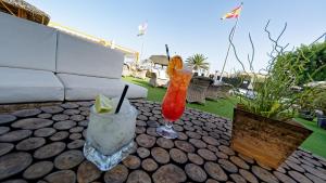 a table with two vases and a drink on it at FBC Fortuny Resort - Adults Only in Maspalomas