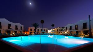 a swimming pool at night with the moon in the sky at FBC Fortuny Resort - Adults Only in Maspalomas