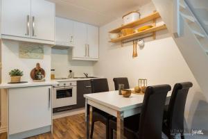 una cucina con armadi bianchi, tavolo e sedie di Actif 305 Apartment by Ål Ski Center ad Ål