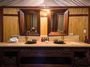 a bathroom with two sinks and two mirrors at aha Thakadu River Camp in Madikwe Game Reserve +31 photos