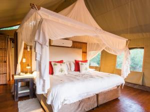1 dormitorio con cama con dosel en una tienda de campaña en aha Thakadu River Camp, en Reserva de Madikwe