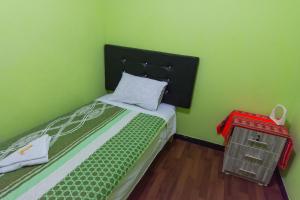 Dormitorio verde con cama con cabecero negro en Hospedaje el viajero-Aeropuerto, en Lima