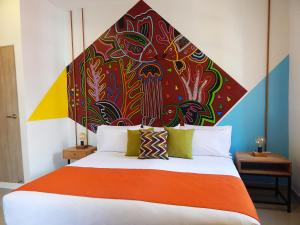 Dormitorio con cama grande y cabecero colorido en ETHNIC Thematic Hotel, en Cartagena de Indias