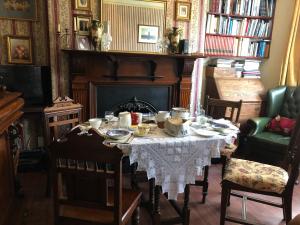 a dining room with a table and a fireplace at Brackenberry in Belfast