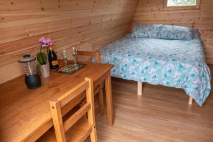 a small room with a table and a bed and a table and chairs at The Moat Lake Glamping Pod in Clare