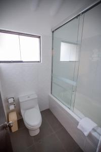 a bathroom with a toilet and a glass shower at Tierra Viva Valle Sagrado Hotel in Urubamba