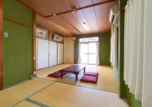 A bed or beds in a room at Minshuku Atsuhama