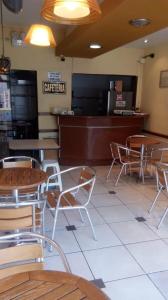 restauracja ze stołami i krzesłami oraz kasą w obiekcie Hostal Resident w mieście Piura