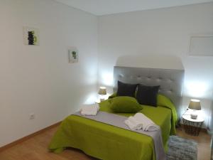 a bedroom with a green bed with two towels on it at Casa Do Boteco in Santa Marta de Penaguião