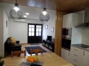 uma cozinha e sala de estar com duas luzes pendentes em Casa Do Boteco em Santa Marta de Penaguião