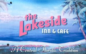 a sign for the lakecastle imc cafe with two palm trees at Lakeside Inn and Cafe in Saint Cloud