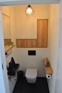 a bathroom with a white toilet and a sink at Modern house in front of the forest in Słupsk