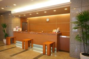 a lobby with a counter with benches and a mirror at Hotel Route-inn Koriyama Inter in Koriyama