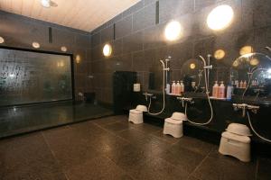 a bathroom with three toilets and a large screen at Hotel Route-inn Koriyama Inter in Koriyama