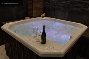 a hot tub with a bottle of wine and glasses in it at Villa Promenada in Międzyzdroje